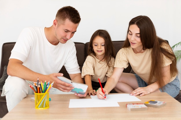 Foto figlia che disegna con i suoi genitori