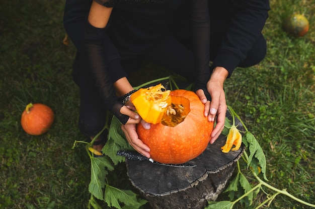 娘と父はハロウィーンのために彫る前にカットカボチャを開いて手を開きますジャックoLanternを準備します