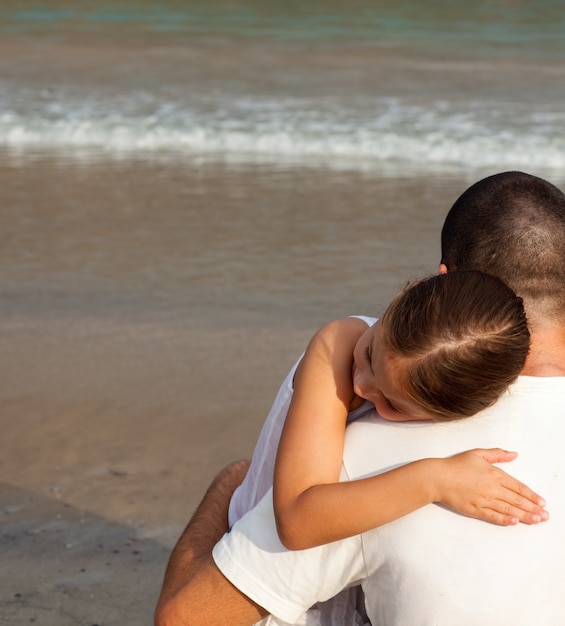 Daughter and father hugging on the beach