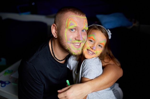 Daughter and father paint a face, having fun