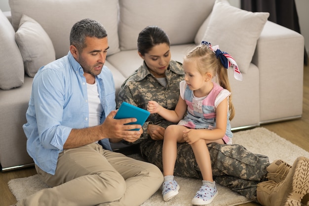 Daughter feeling excited. Daughter feeling excited before watching cartoon on tablet with dad and mom