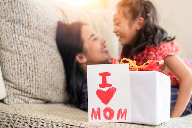 Daughter give mother day greeting card to mom