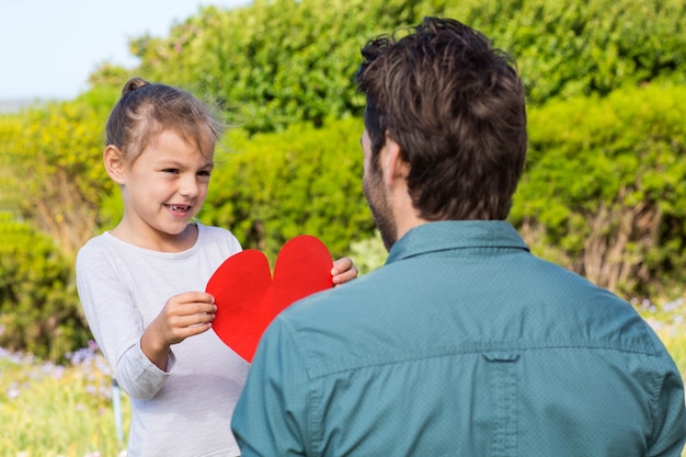 Foto figlia che dà a papà una carta del cuore