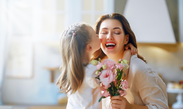 Daughter giving mother bouquet of flowers