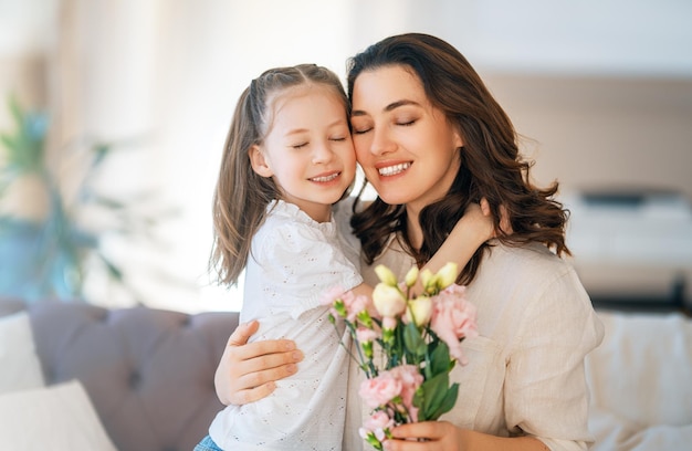 daughter giving mother bouquet of flowers
