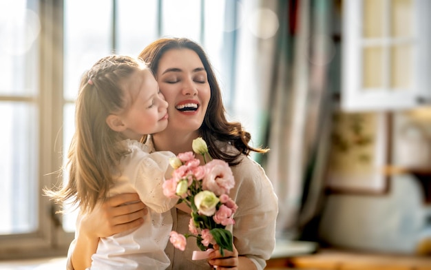 Daughter giving mother bouquet of flowers