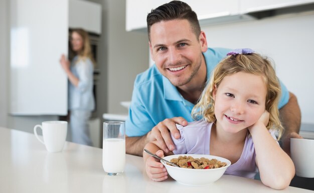 父親とテーブルで朝食を取る娘