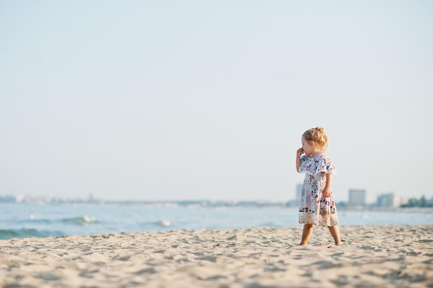 Daughter having fun on the beach Portrait of happy cute little baby girl on vacation