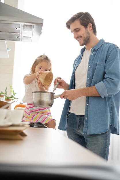 父が台所で食事を作るのを手伝っている娘。