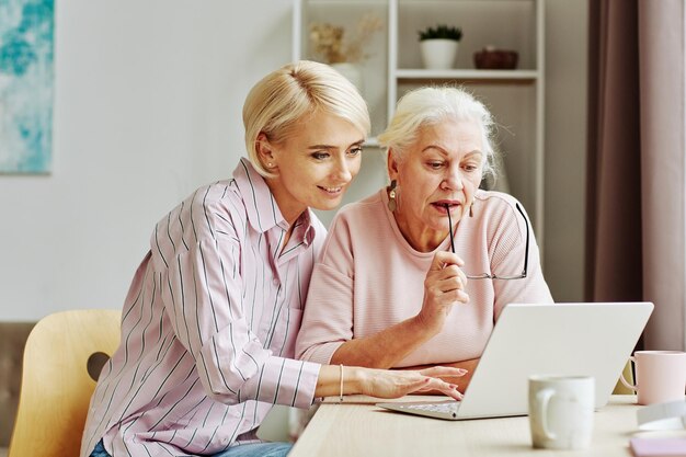 Daughter Helping Senior Woman with Laptop