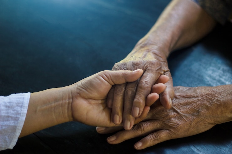 Photo daughter holding hand of mother elderly that is alzheimer and parkinson patient