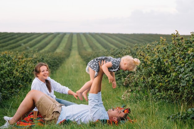 The daughter hugging parents on nature.