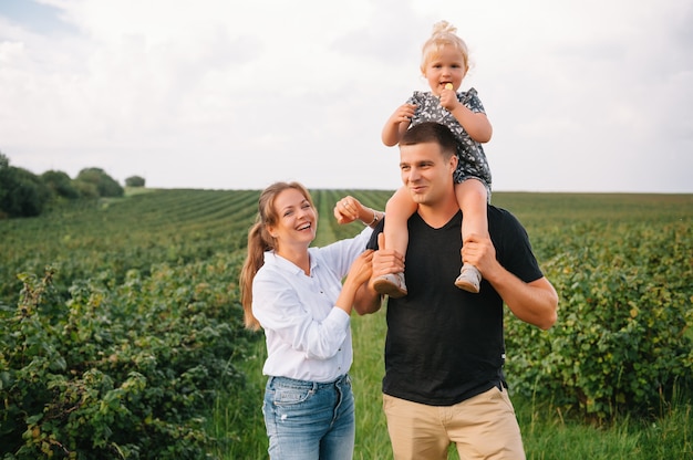 The daughter hugging parents on nature.