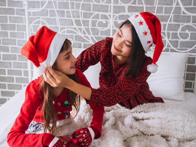 Photo the daughter and mother celebrate christmas day in the house