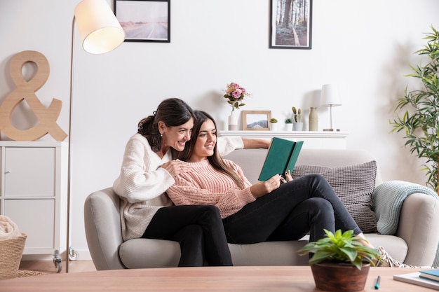 Photo daughter and mother on couch reading