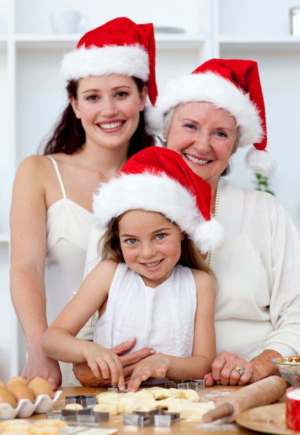 Daughter, mother and grandmother baking Christmas cakes