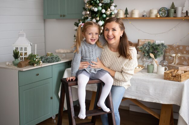 Daughter and mother smiling in Christmas background