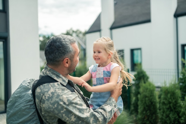 写真 笑顔の娘。兵役後のパパを見ながら笑っている陽気なブロンドの髪の娘