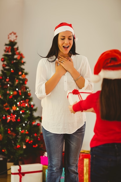 彼女の母親がクリスマスプレゼントで驚く娘