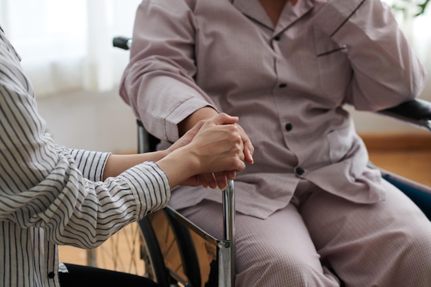 Figlia che tocca le mani della madre anziana