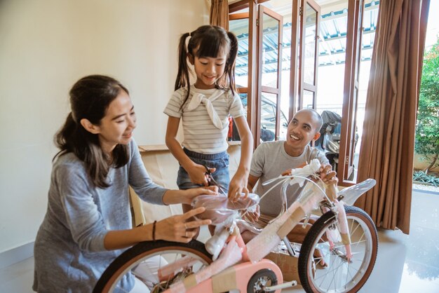 娘は新しいミニバイクを持っている間、プラスチックを開梱します