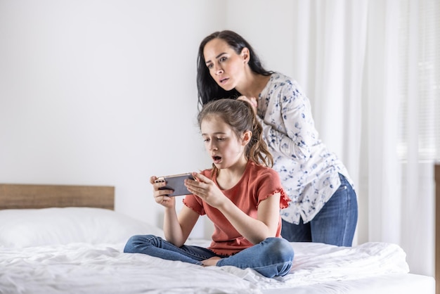 Daughter watches shocking video on a phone while her mother tries to control the online content her kid watches