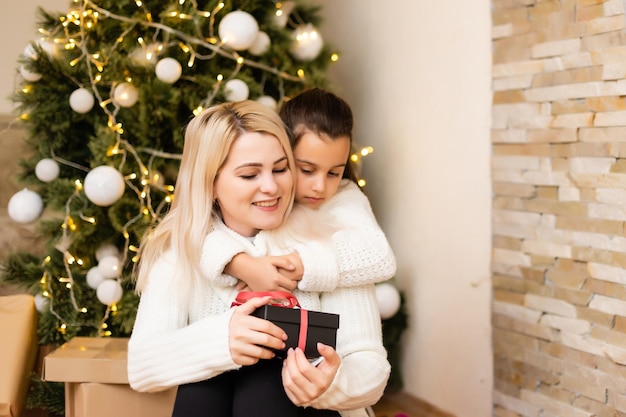 Daughter with her mother near the Christmas tree.