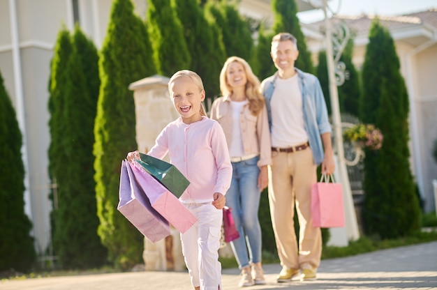 daughter with purchases and hugged parents behind