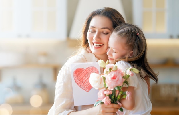 daughters giving mother bouquet of flowers