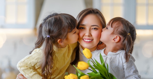 Daughters giving mother bouquet of flowers