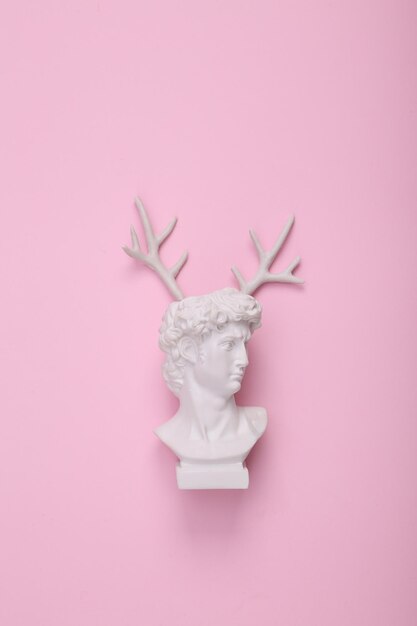 Photo david bust with antlers on pink background creative layout concept pop minimal shopping still life flat lay top view