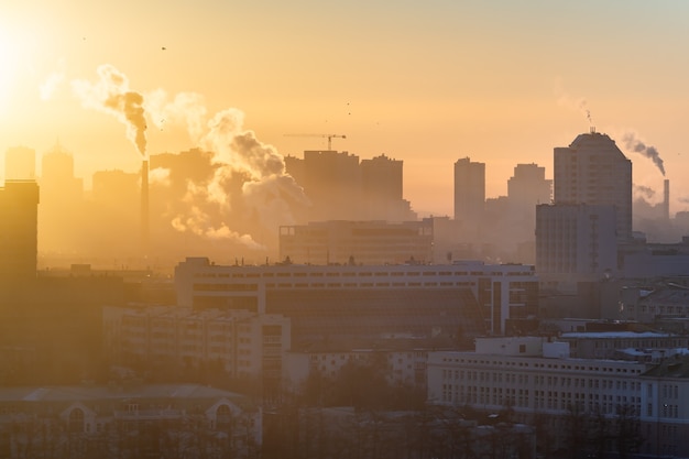 Alba sopra la città. il sole illumina lo smog sulla città