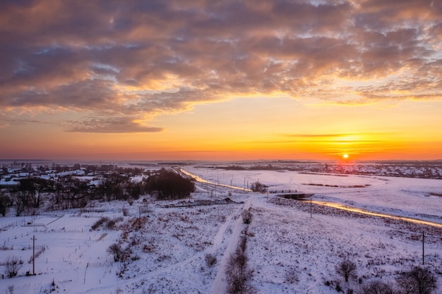 Dawn in de winter over het veld in de sneeuw