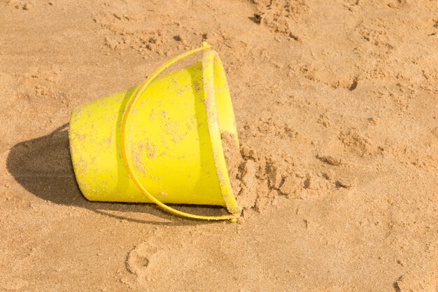 Photo day at the beach with a bucket in the foreground.