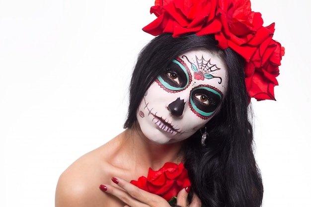 Photo day of the dead. halloween. young woman in day of the dead mask skull face art and rose. isolated on white. closeup.