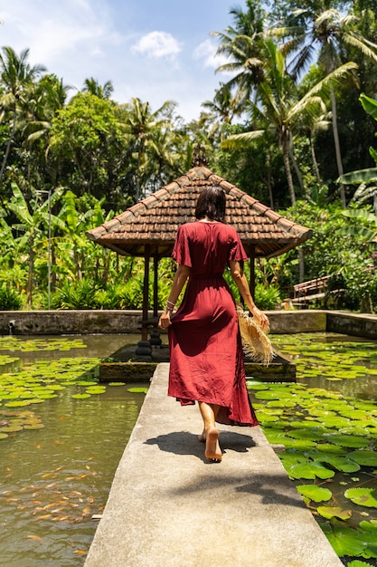 Photo day of relaxation. pleased brunette girl looking forward while enjoying exotic nature