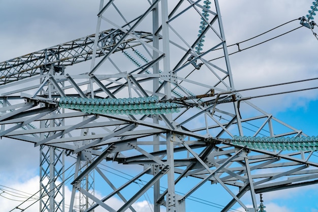 Day view of electric wire station Dark electric energy technologies Pylons or transmission towers in countryside on beautiful blue sky background Cropped view