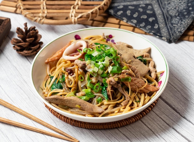 Dayang Chun Noodles Droog in een schotel geïsoleerd op houten tafel zijaanzicht Taiwan eten