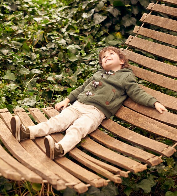 Daydream the day away A little boy relaxing in a hammock in his backyard