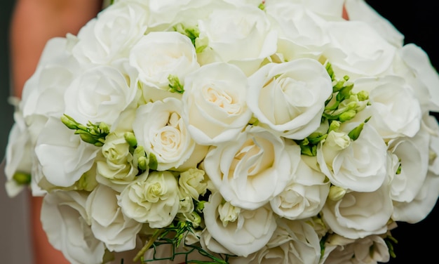 Foto un bouquet di rose bianche nelle mani di una donna