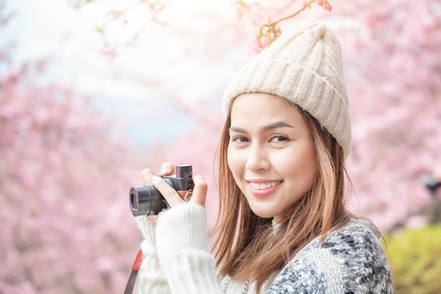 De aantrekkelijke vrouw geniet van met Cherry Blossom in het park