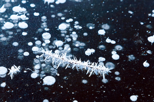 De achtergrond van de ijstextuur met bevroren stok en bellen