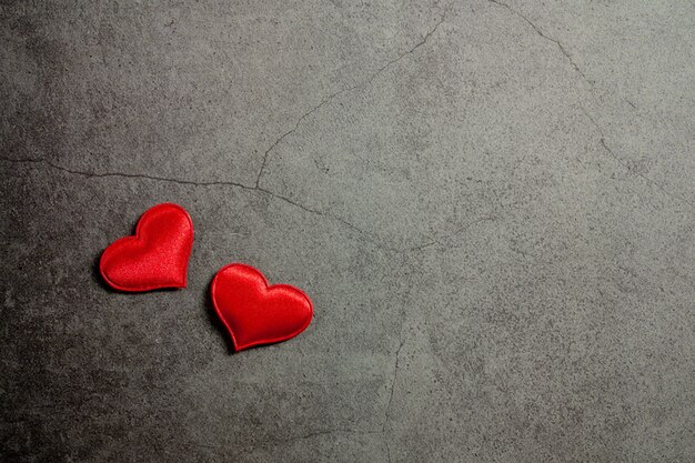 De achtergrond van de valentijnskaartendag met rode harten op oude concrete lijst
