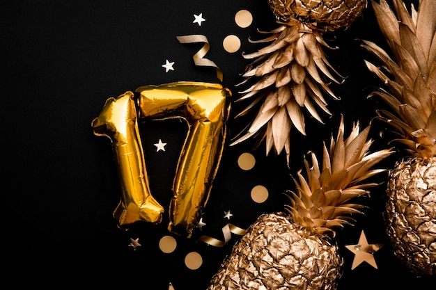 De achtergrond van de verjaardagsviering met gouden ballonnen en gouden ananas