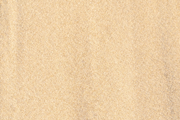 De achtergrond van de zandtextuur op het strand. Licht beige zee zand structuurpatroon, zandstrand achtergrond.