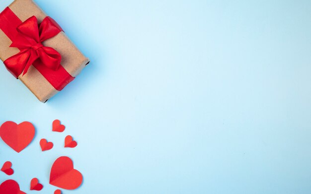 Foto de achtergrond van valentijnsdag. geschenken, harten, rood lint op pastelblauwe tinten. het concept van valentijnsdag. bovenaanzicht, kopie ruimte