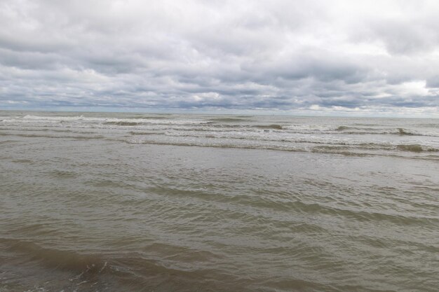 Foto de achtergrond van zee en blauwe lucht over een wit zandstrand in de stijl van donkere