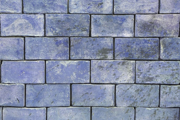De achtergrondstructuur van een bakstenen muur is lichtblauw, paarse tinten zijn grote blokken