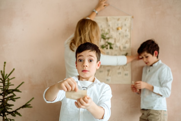 De adventskalender die aan de muur hangt. cadeaus verrassingen voor kinderen. twee emotionele jongens