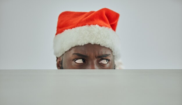 Foto de afrikaanse man met de kerstmuts kijkt toe vanaf de tafel